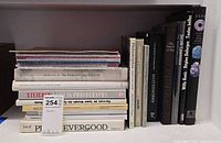 Shelf with horizontal stack of periodicals and art books alongside vertical row of additional art books