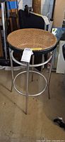 Full view of round cane seat stool showing frame and seat