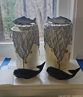 Front view showing both jars with fish finials and both whale figures