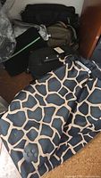 Giraffe-print Rolser wheeled bag with other bags stacked behind