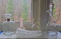 Group view of both decanters, cornucopia vase, pink bud vase, clear bud vase