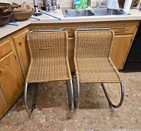 two armless rattan chrome chairs front view