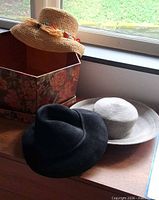 Overview of three hats and floral hat box