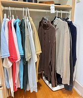 Row of assorted polo shirts and sweaters on hangers
