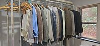 Rack with assorted men’s jackets, shirts, pants on hangers