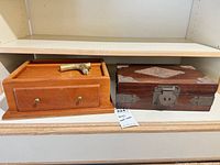 Two wooden valet boxes and brass cane handle on shelf