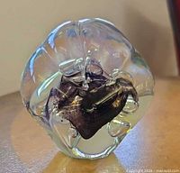 Front view showing clear glass body, purple core, bubbles