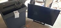 Overall view of shredder bin and Vizio TV with stand