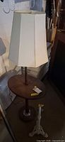 Floor lamp with attached table and shade beside cast iron stand