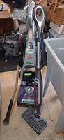 Bissell carpet cleaner and Shark steam mop standing together