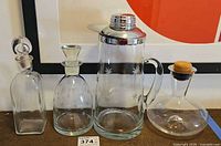 Four glass decanters and pitcher lined up