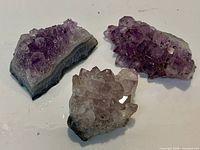 Three amethyst crystal clusters on white background