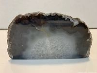 Front view of banded agate geode slice showing polished face and crystalline interior