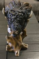 Rear view of painted resin bison head on faux wood base showing texture, horns, and overall condition