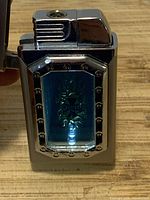 Lighter open showing blue decorative panel with Choppers logo and lit LED