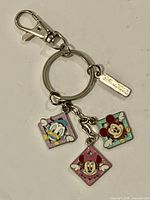 Full keychain showing split ring, lobster clasp, Disney logo tag and three character charms