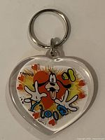 Front view of clear acrylic heart keychain showing Goofy graphic and metal split ring