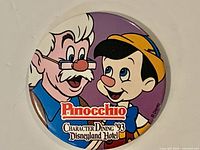 Front view of 3-inch round button pin showing Pinocchio and Geppetto graphics and text