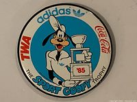 Front of round Disney Sport Goofy Trophy button showing graphic, sponsor logos, ’85 date