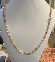 Full view of gold-tone chain necklace with faux pearl sections displayed on bust