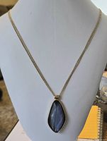 Full view of necklace on display bust showing chain length and pendant size