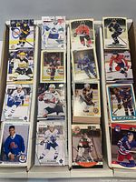Front view of two rows of assorted hockey cards with visible player fronts