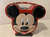 Front view of Mickey Mouse tin bank showing graphic and shape