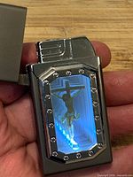 LED hologram lighter open, blue LED lit, crucifixion image visible