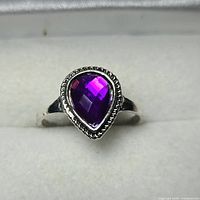 Front view of silver-tone ring with purple pear stone