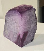 Front and side view of polished dyed pink agate geode showing polished surfaces and rough top