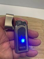 Lighter open showing ignition end, blue LED illuminated
