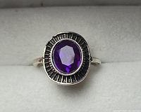 Top view of silver-tone ring showing purple stone and bezel details