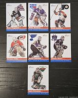 Seven Topps Heritage style hockey cards arranged on black surface