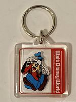 Front view of acrylic Goofy keychain showing graphic, logo and metal ring