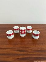 Front view of four egg cups and shaker showing pattern