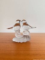 Front view of clear and frosted crystal birds figurine on wood surface
