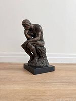 Full front-left view of bronze-tone The Thinker replica on black base