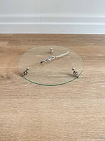 Overall view of glass tray on silver-plated feet with knife