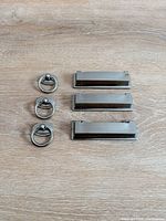 Three ring pulls and three rectangular pulls on wood background