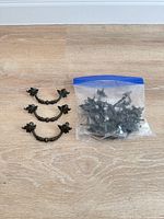 Three drawer pulls displayed next to a sealed bag containing many more handles and screws