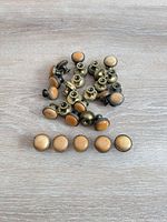 Cluster of vintage brass and wood cabinet knobs displayed on wood surface