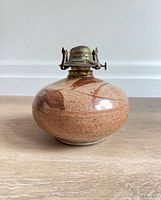 Front view of ceramic oil lamp base with brass burner attached