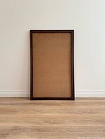 Front view of empty wooden frame standing against wall