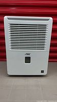 Front view of Arctic King dehumidifier showing grille and bucket window