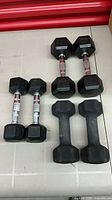 All six dumbbells arranged showing different styles and weights