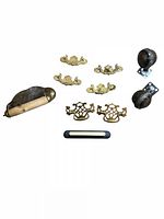 All hardware pieces laid out: brass drawer pulls, ball casters, toilet paper holder, black pull