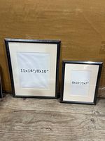 Both black picture frames standing side by side showing size labels