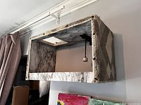 Side view of rectangular cat shelf showing gray looped carpet exterior and open front