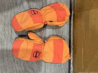 Top view of both orange striped Kombi mittens