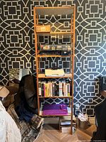 Full view of ladder bookshelf showing five shelves and natural finish